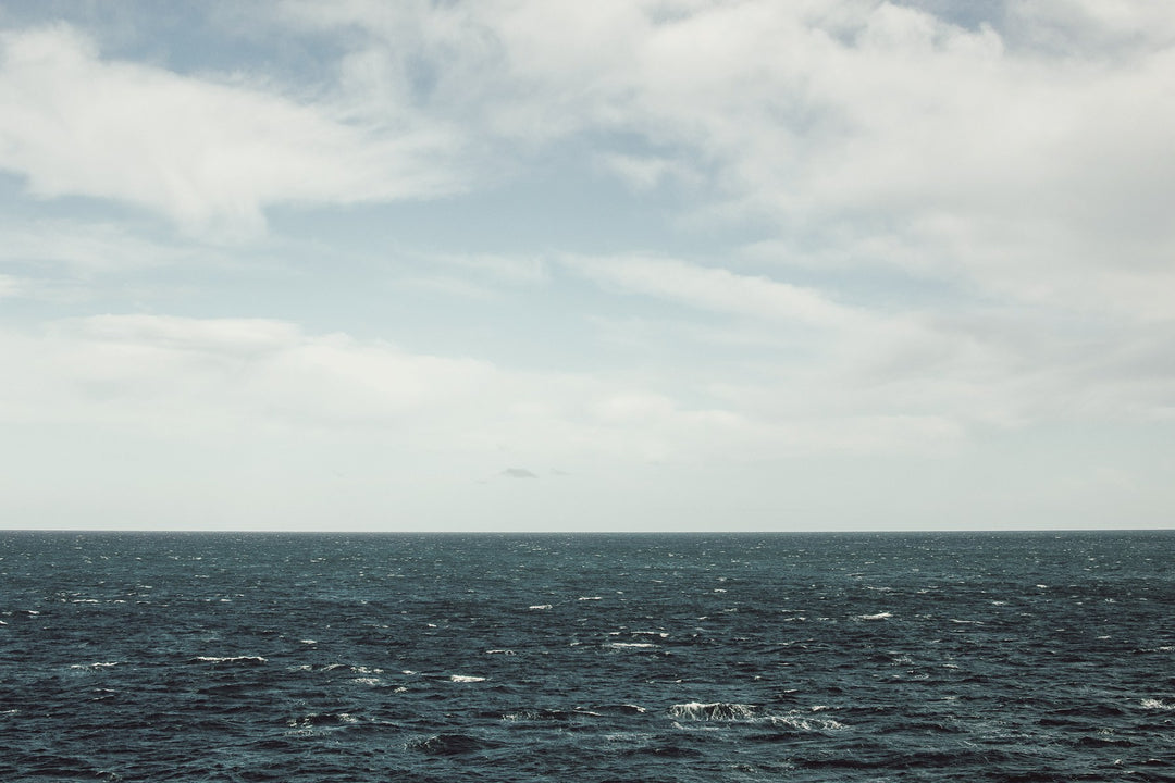 The open sea under a wide, cloud-streaked sky