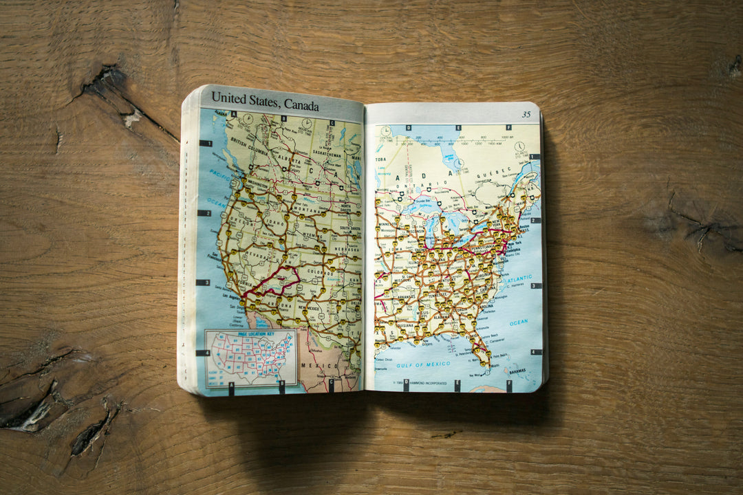 A paper road map spread open on a weathered wooden surface