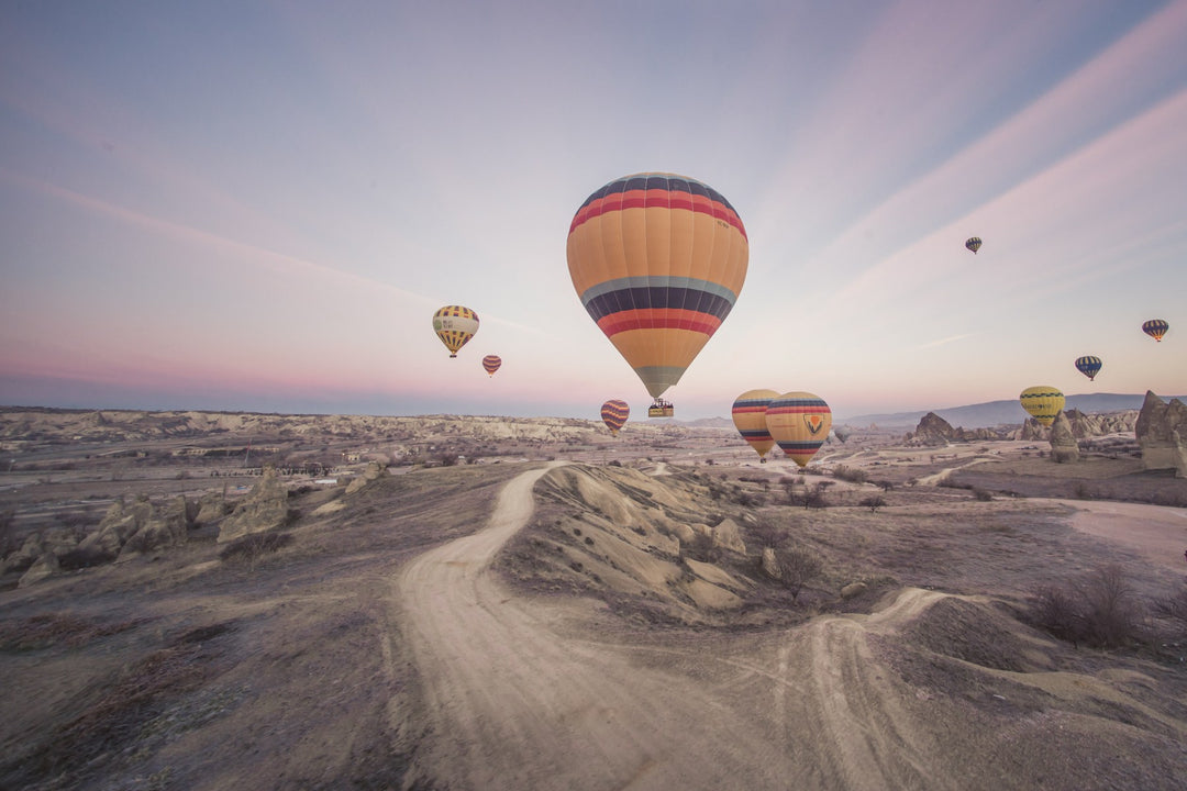 Hot air balloons over a desert valley at dawn
