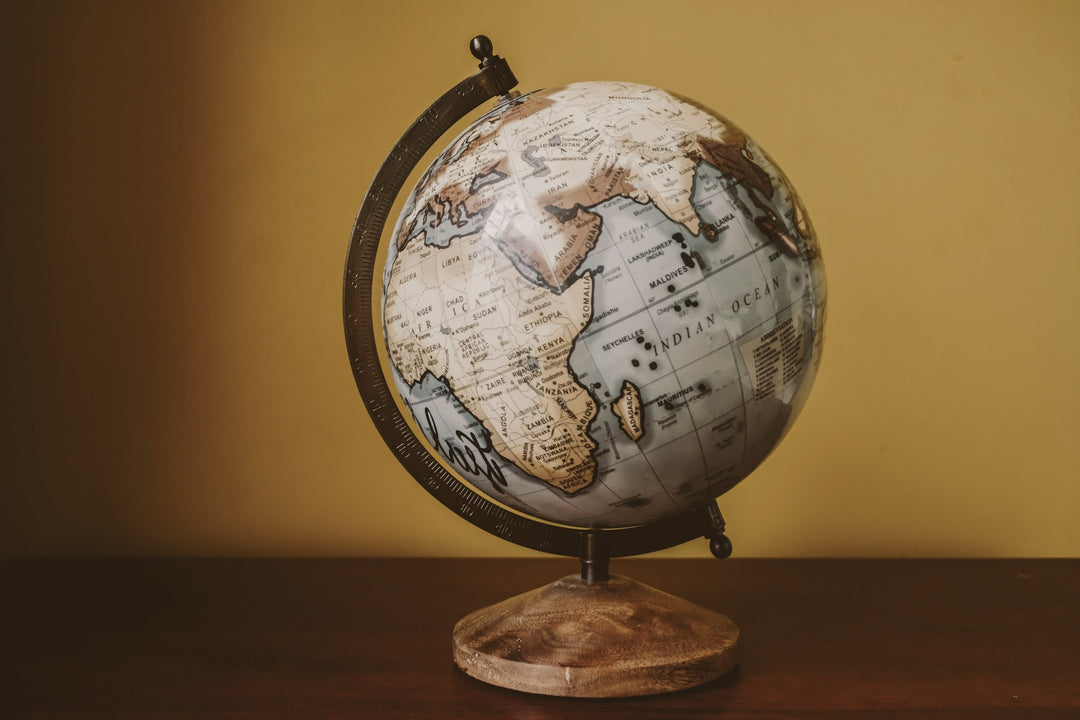 A vintage globe on a desk in warm light