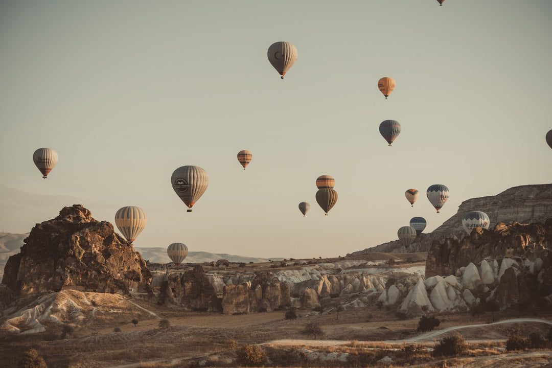 Hot air balloons rising over a rocky valley at sunrise