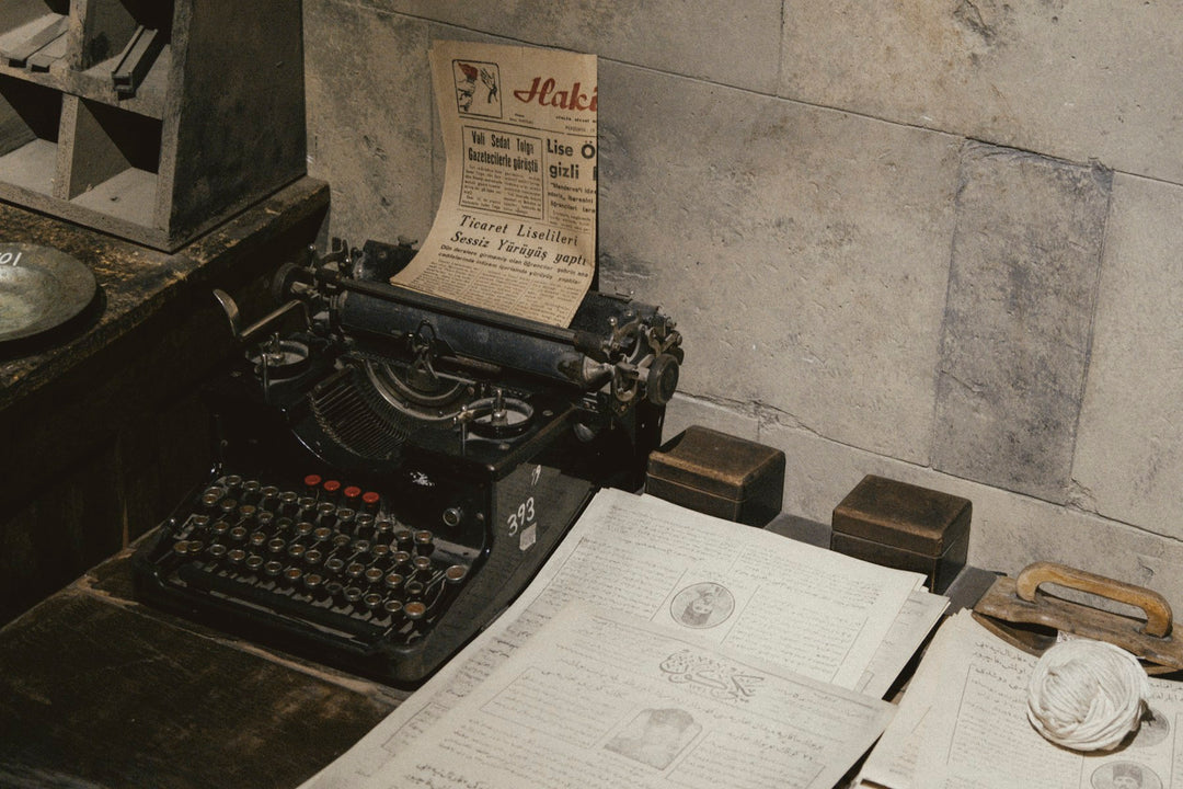 An old typewriter on a cluttered writing desk
