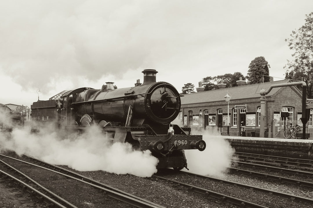 A vintage steam locomotive pulling into a station