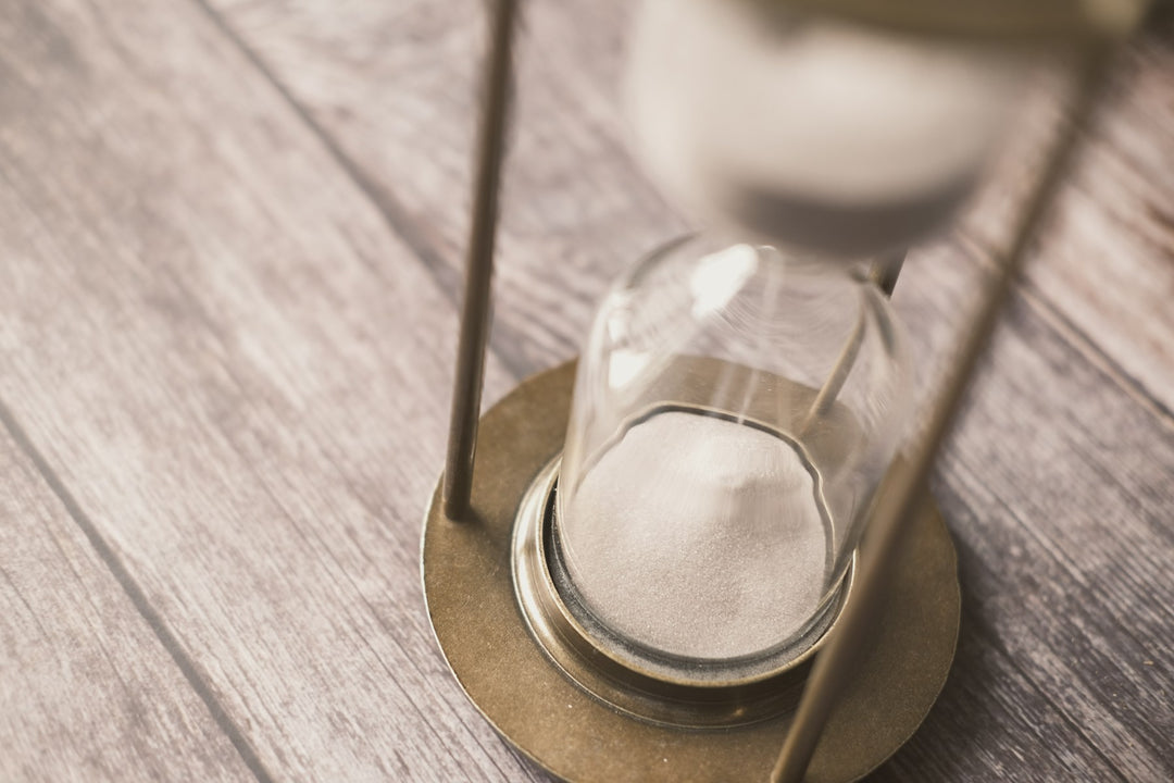 An hourglass on a wooden table