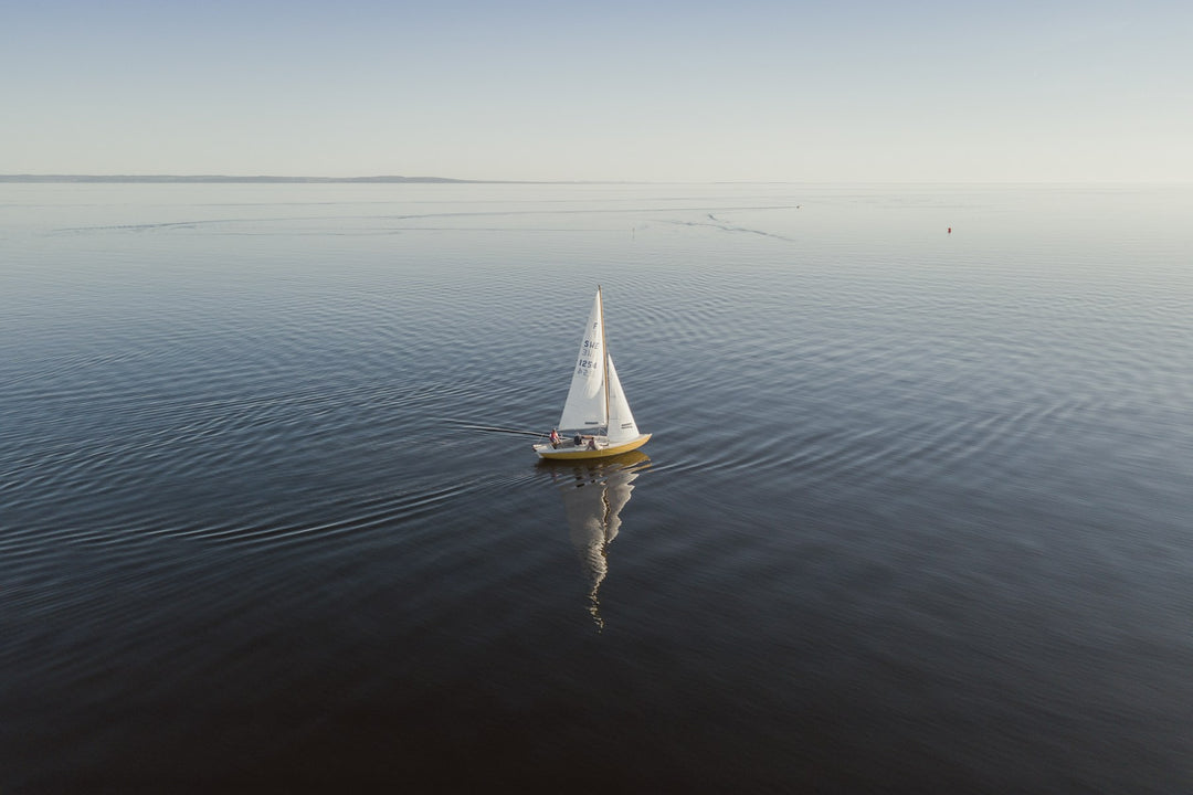 A lone sailboat on a calm blue sea