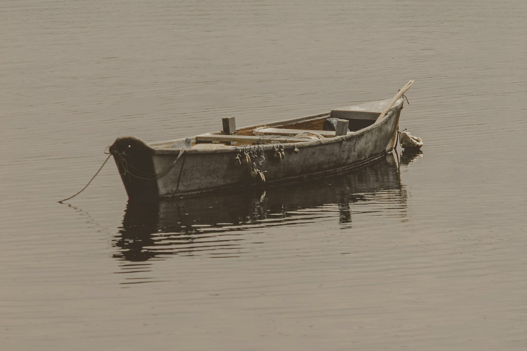 An old wooden rowboat floating on still water