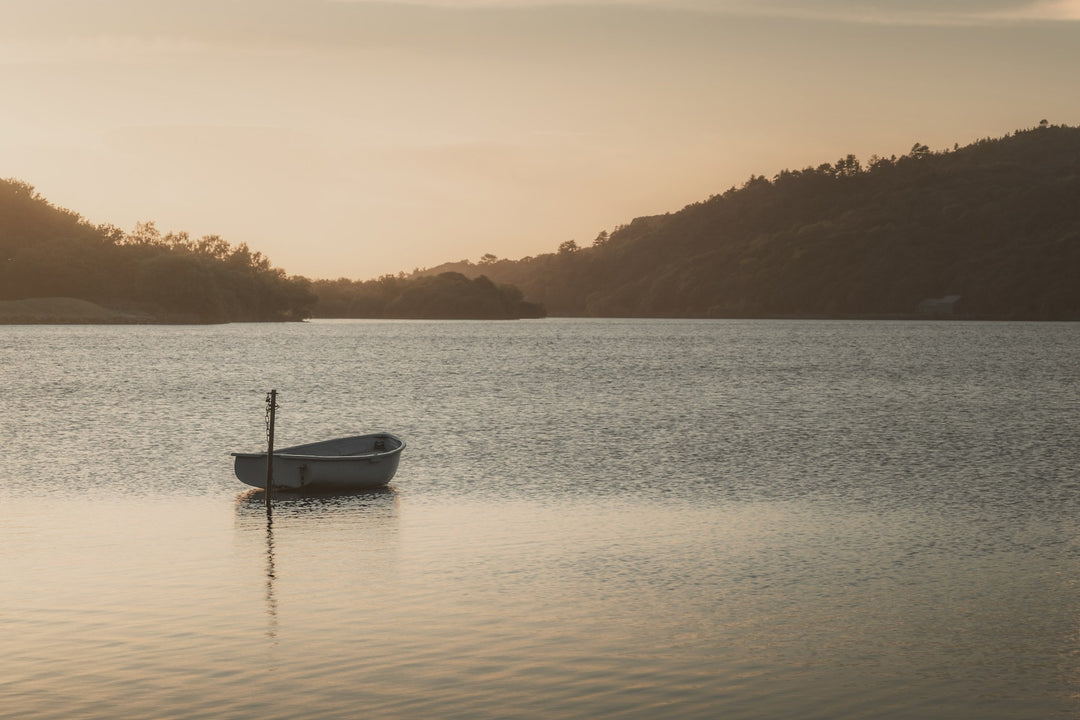 A small boat on a still lake at dusk