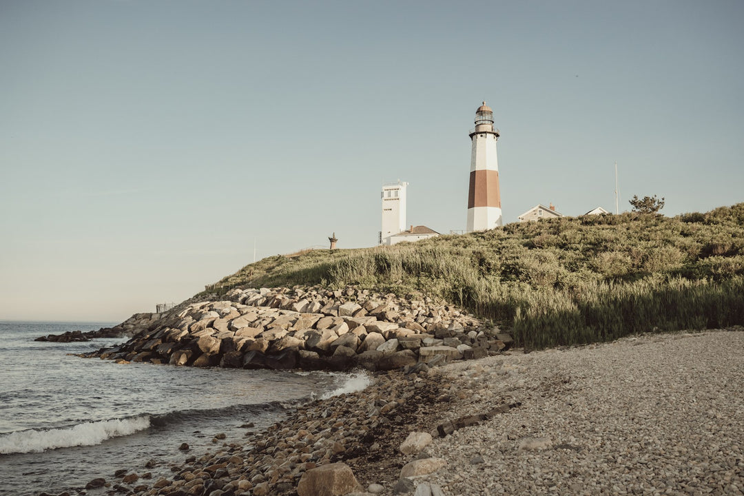 A red and white lighthouse on a rocky shore