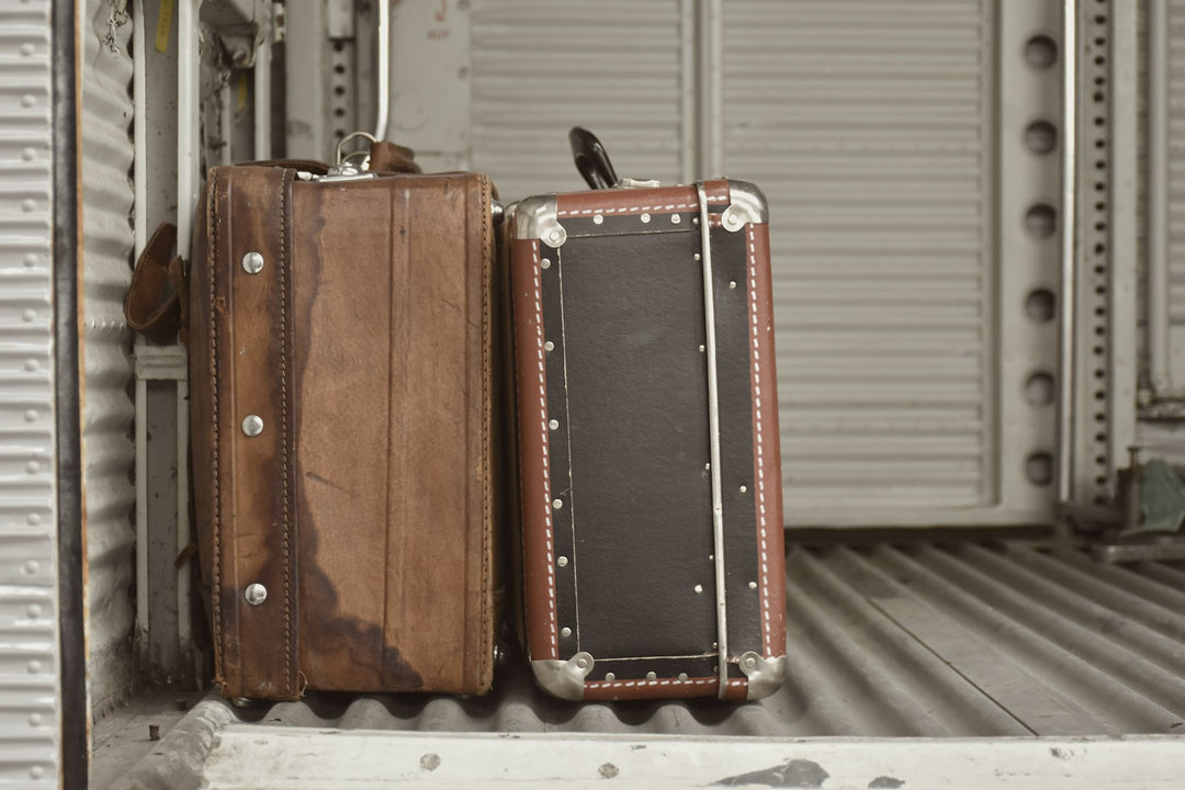 Two vintage suitcases waiting by a door