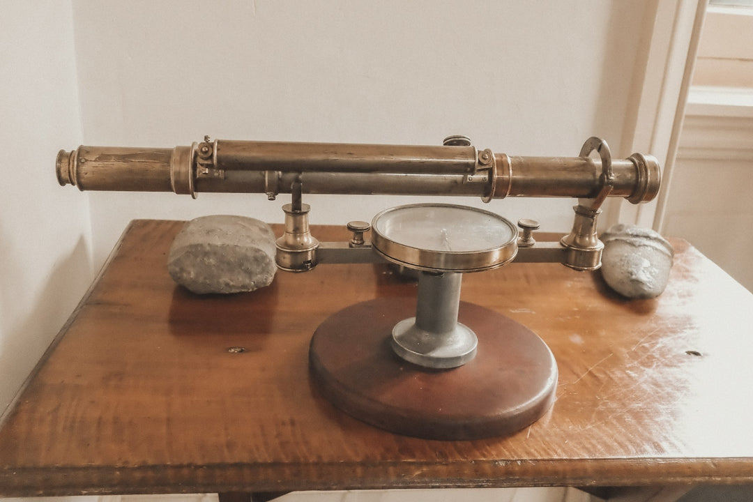 An antique brass telescope on a wooden stand