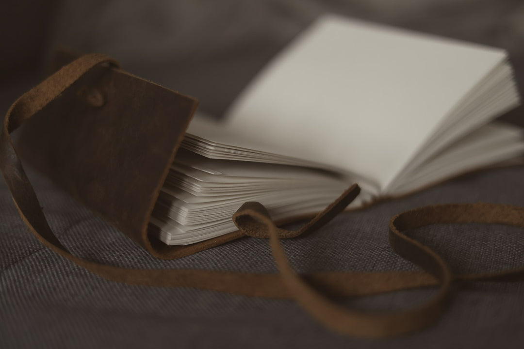 A leather-wrapped journal with loose cream pages